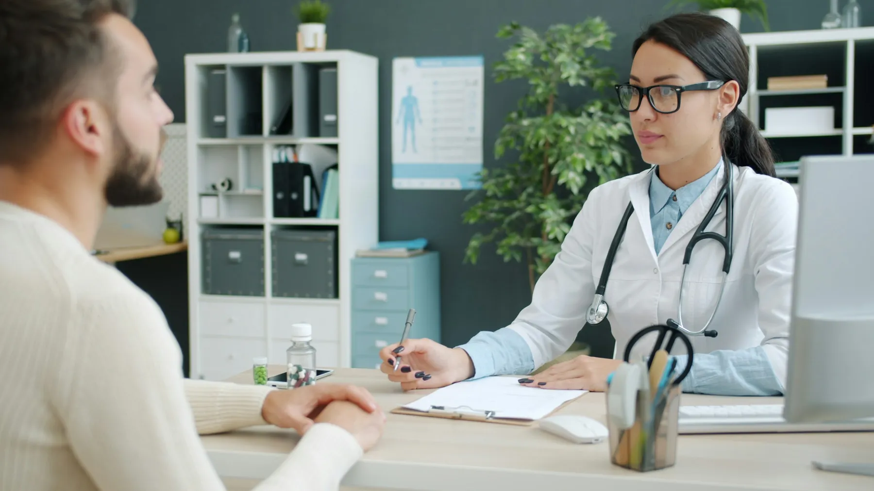 Médica conversando com paciente em consultório claro e organizado