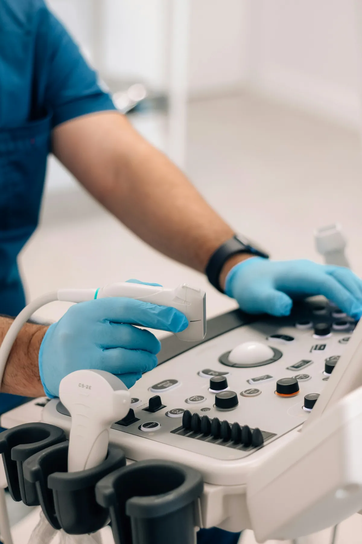 Profissional de luvas operando aparelho de ultrassom