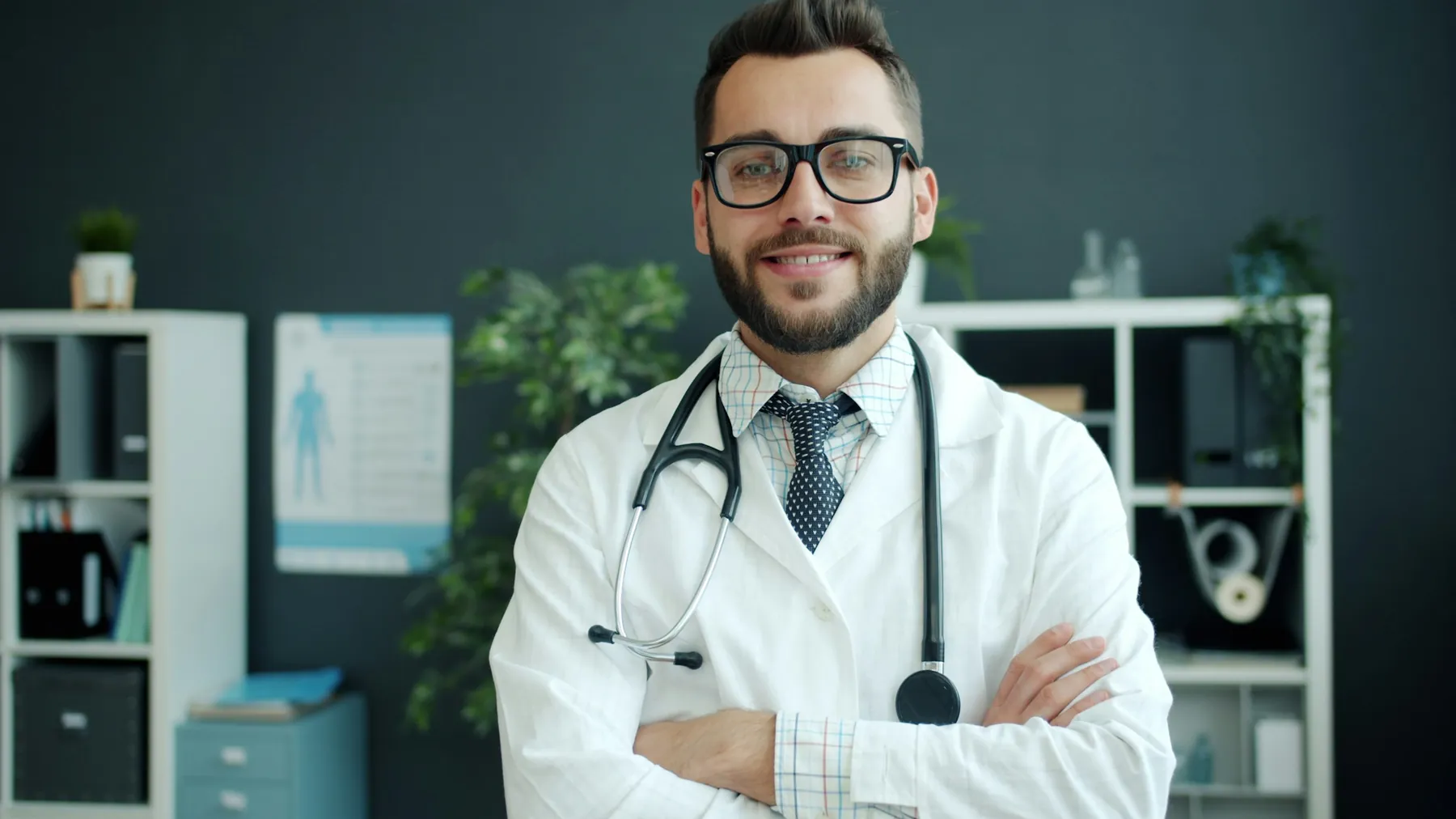Médico sorridente de jaleco e estetoscópio, de braços cruzados