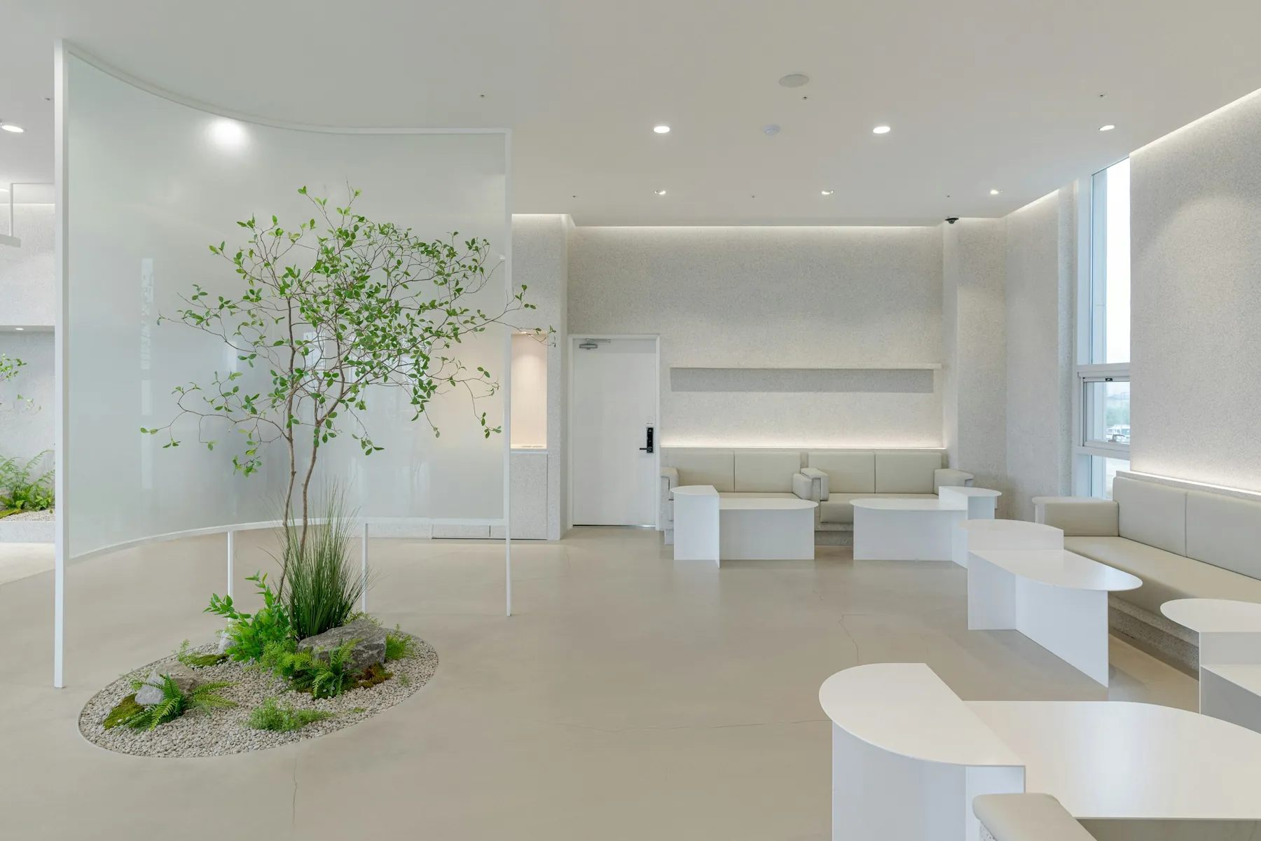 Recepção moderna e clara da clínica, com jardim interno