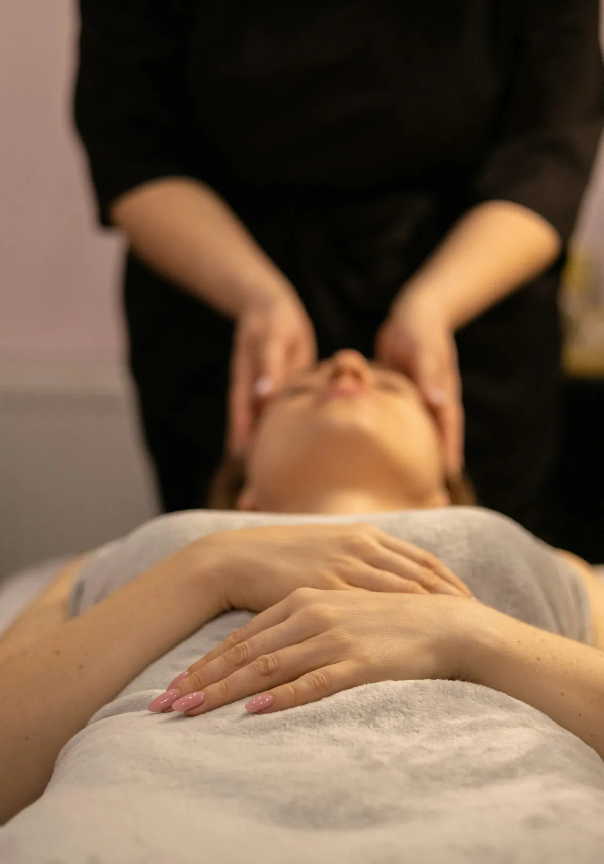 Esteticista faz massagem facial em cliente deitada